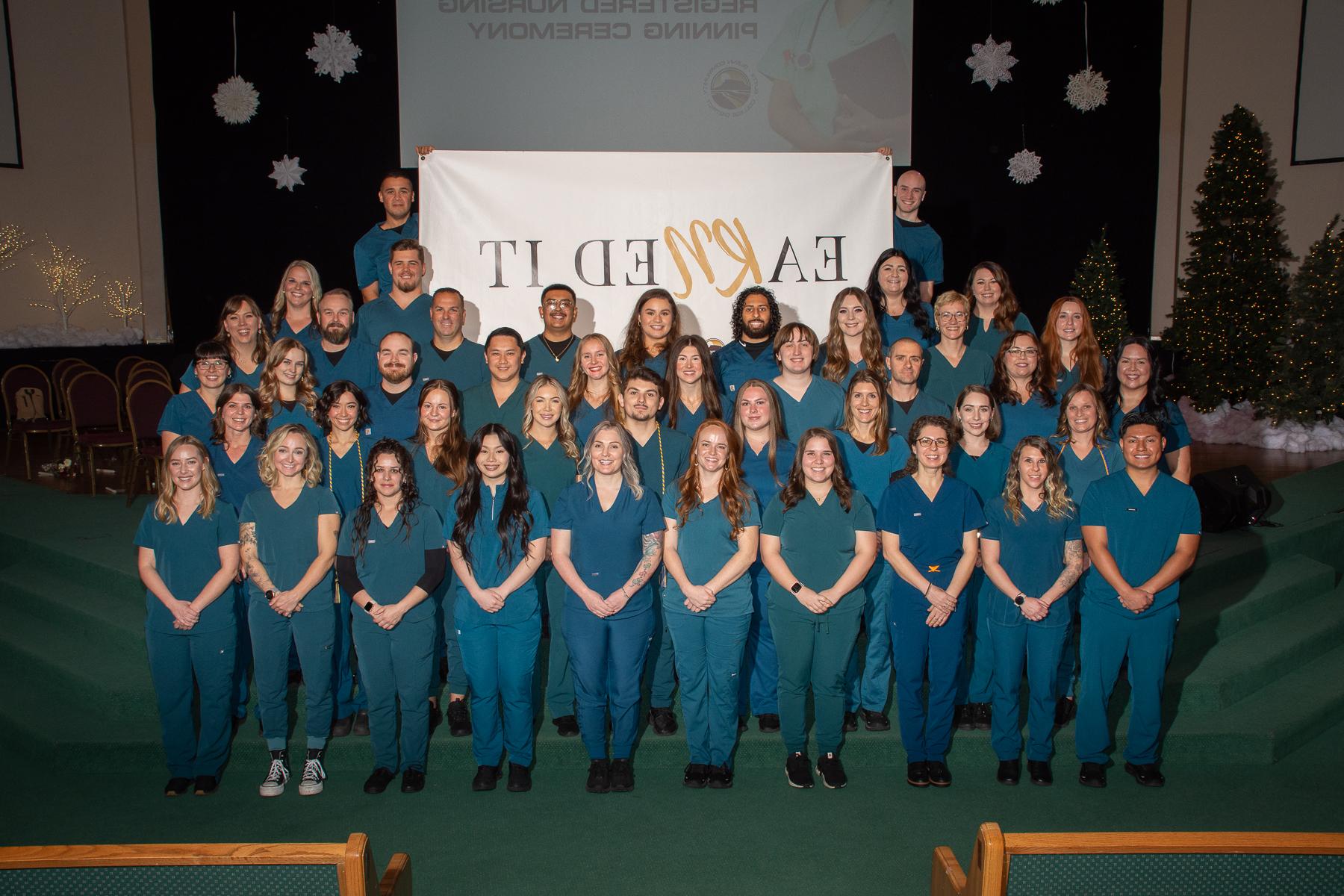 The gradutes pose together in their scrubs. 